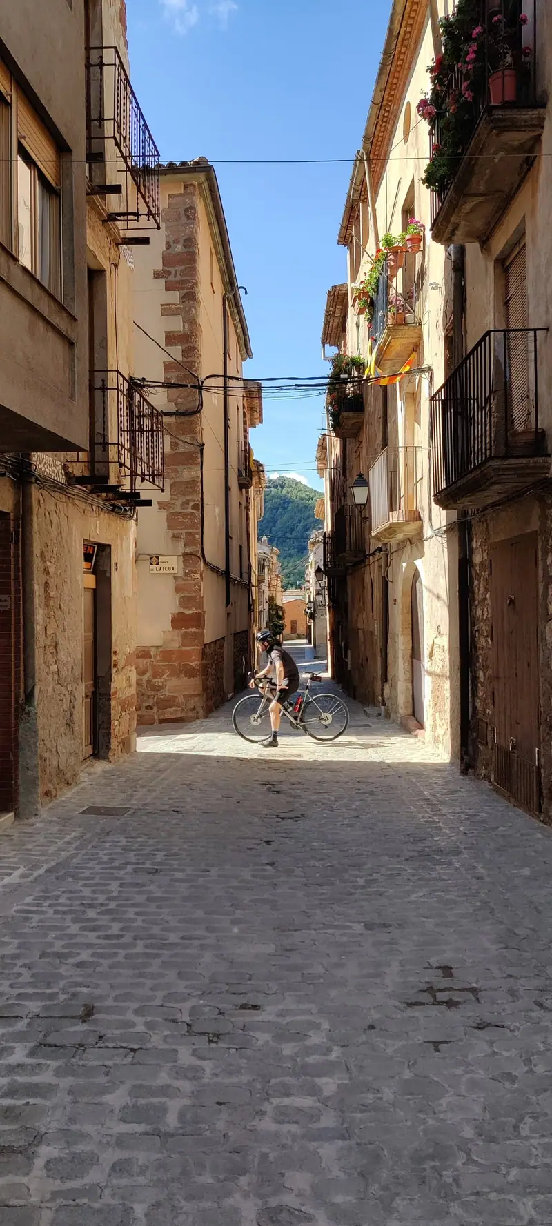 A cyclist riding up a narrow street in the old town
