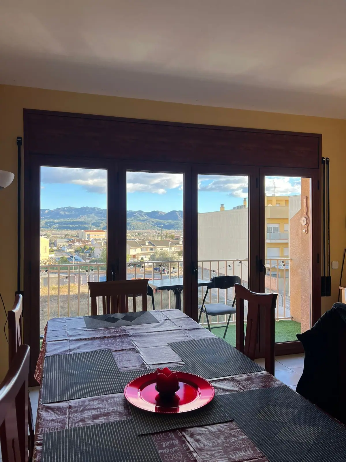 Dining table beside the balcony doors, looking out to the mountains
