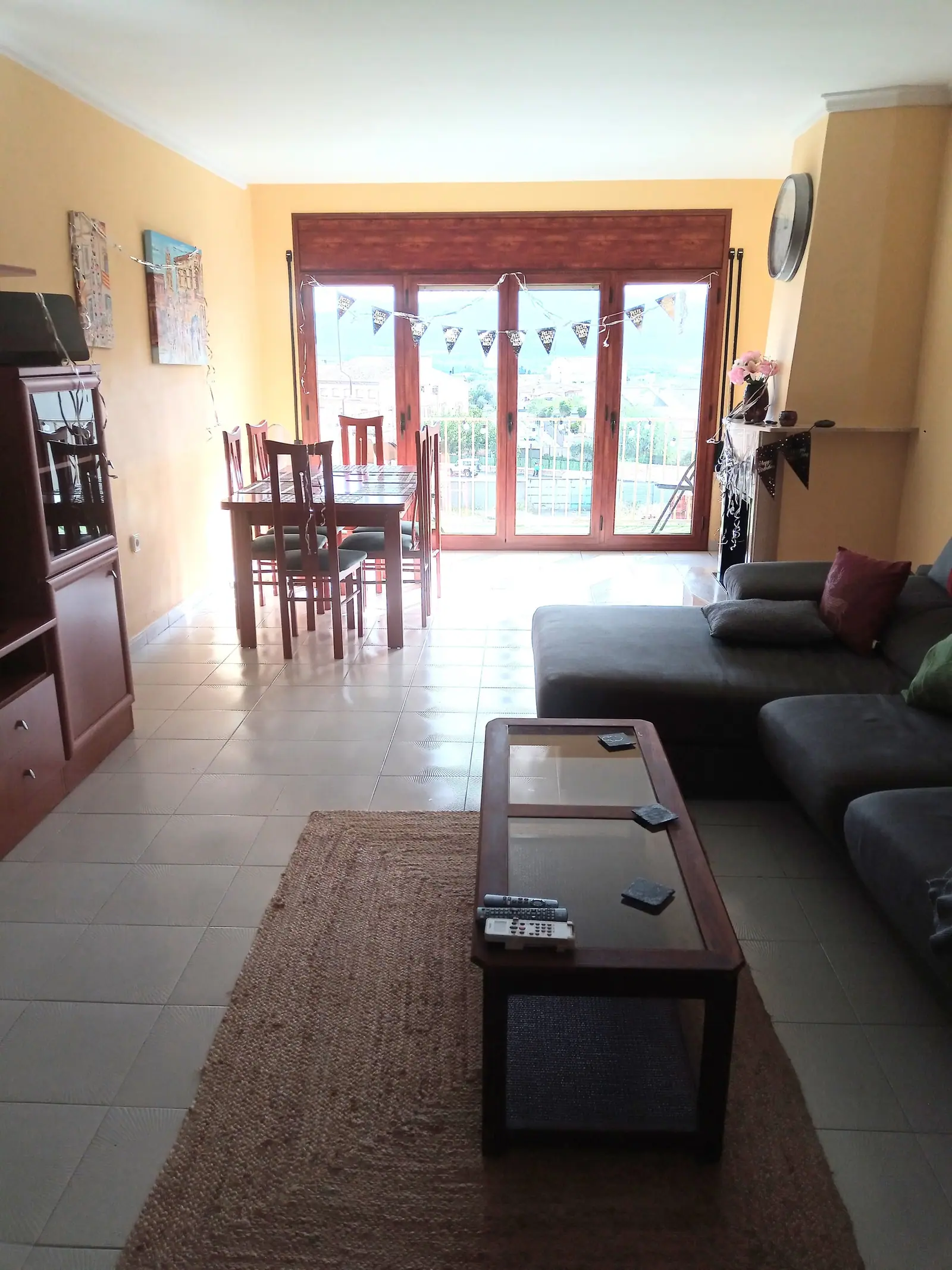 Open living and dining space with a corner sofa and balcony doors