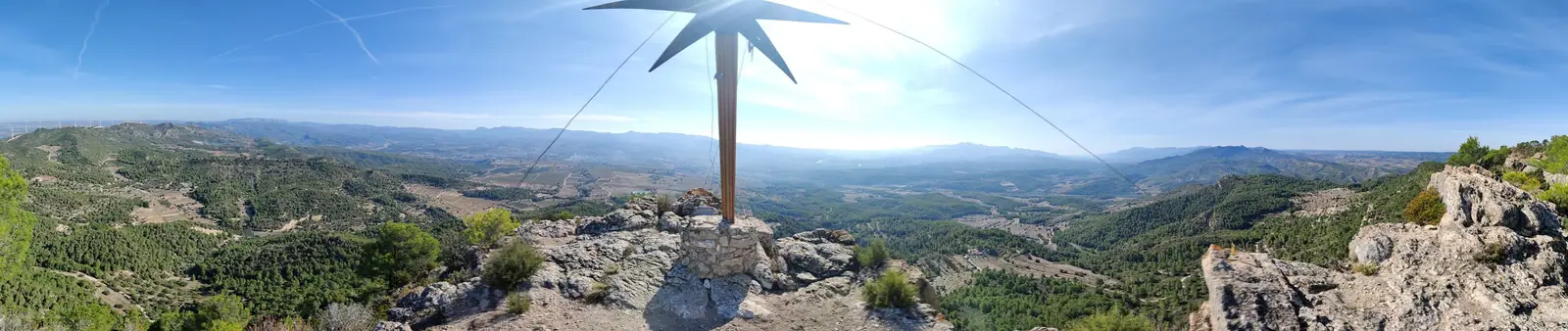 Summit marker on a rocky peak above the valley